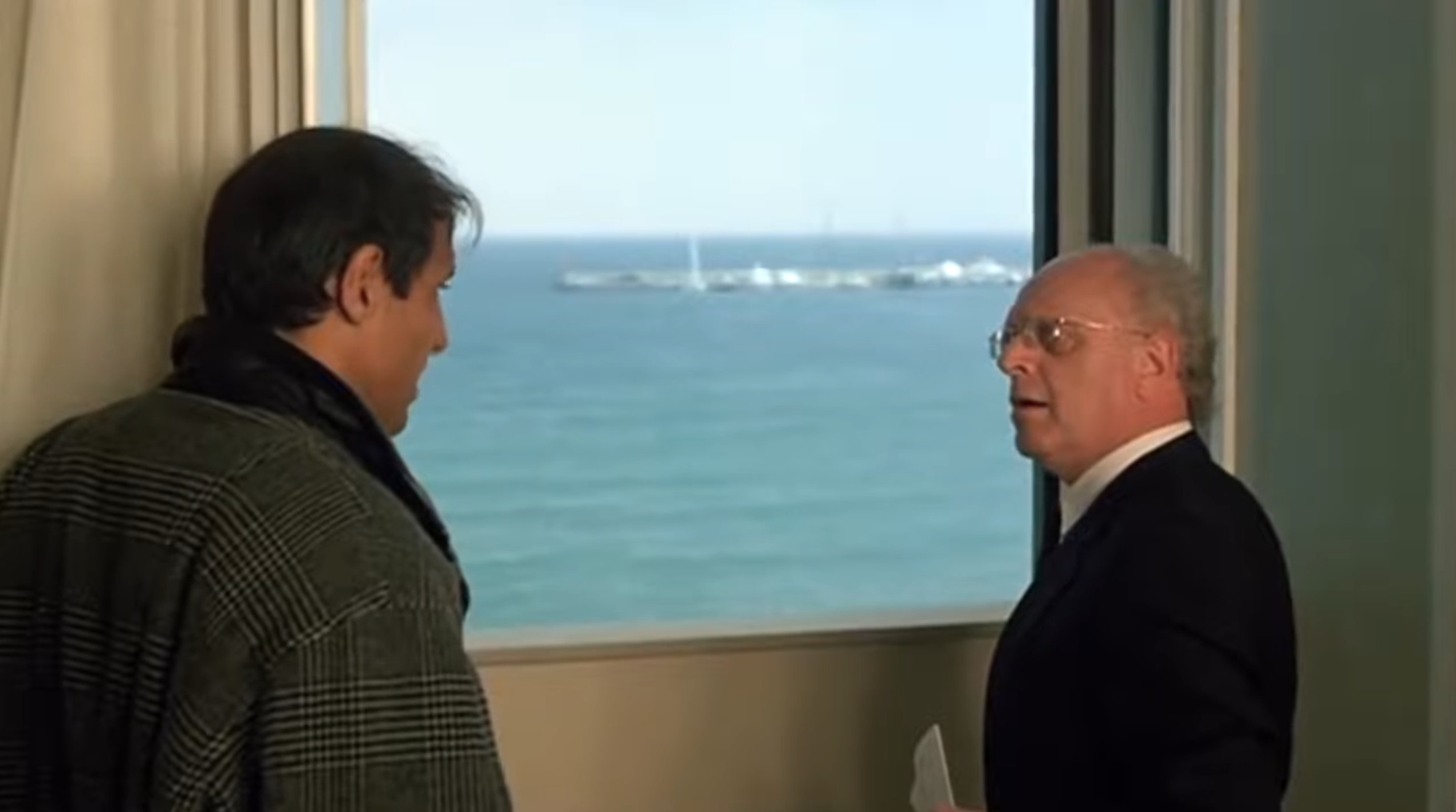 Due uomini (uno è Adriano Celentano) guardano il mare da una finestra